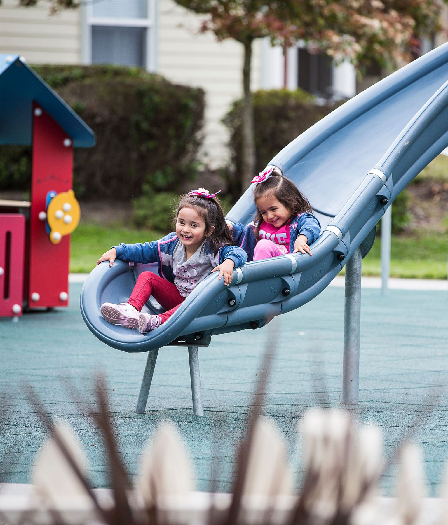 Two little girls on a blue slide